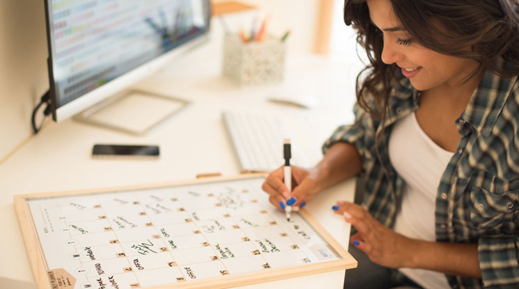 Woman writing with dry erase marker