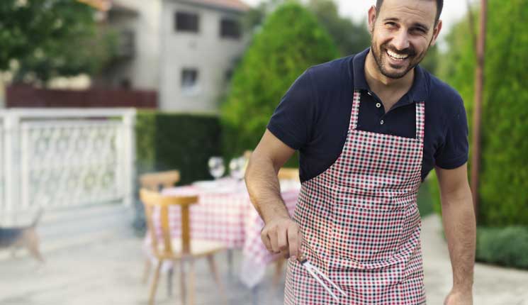 Man in apron grilling