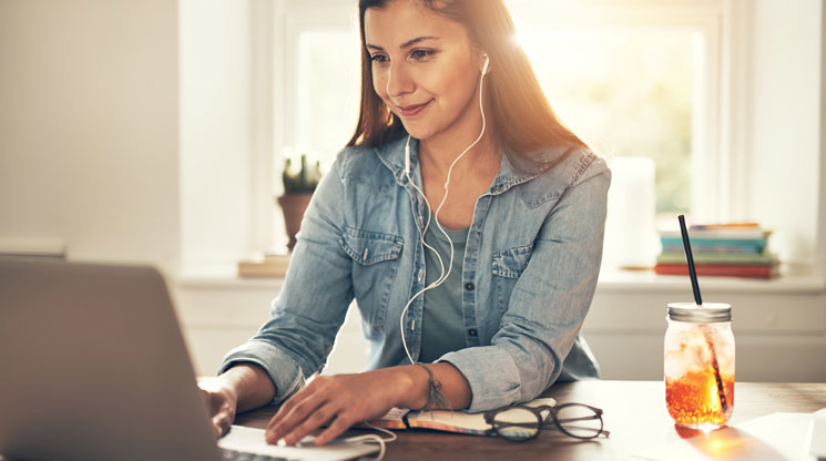 Woman working on computer listening to music