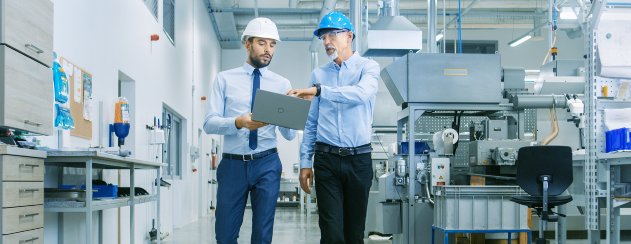 men walking through factory building