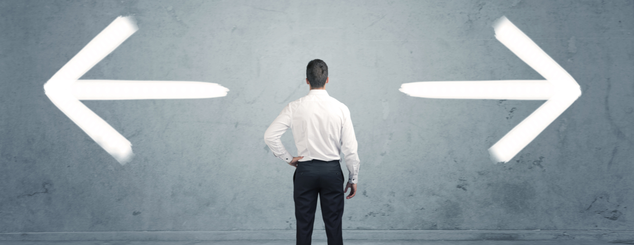 man looking at arrows pointed in different directions