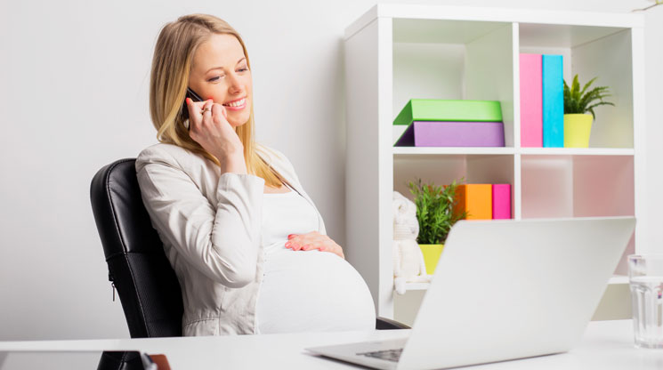 Pregnant woman working at computer